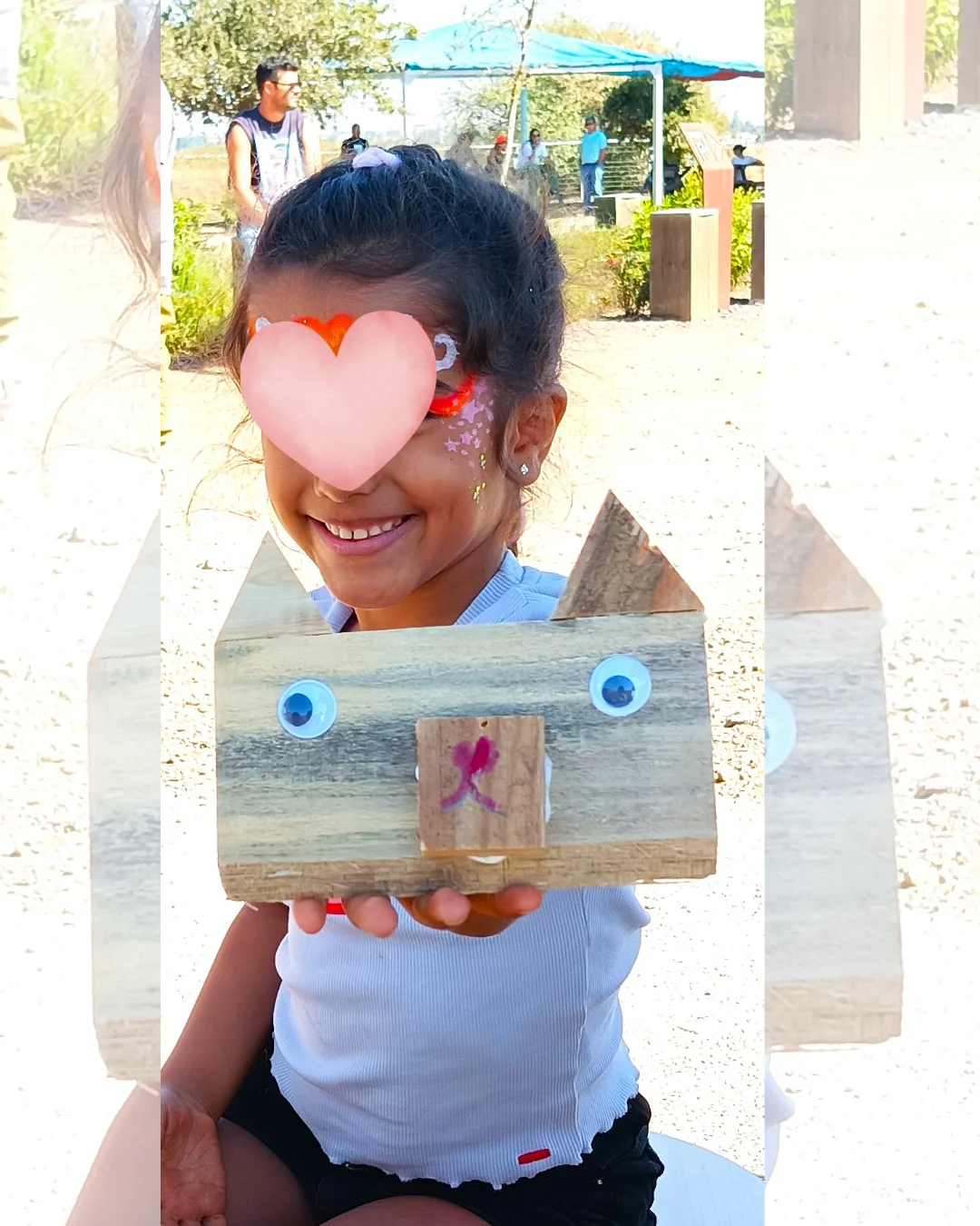ילדה מחזיקה יצירה חופשית מעץ