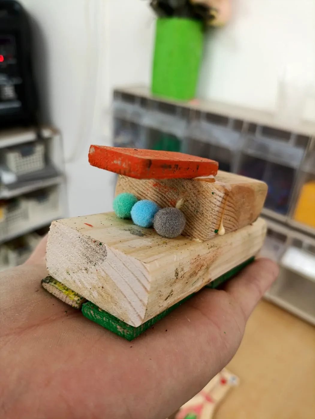 יצור מעץ טבעי עם גג אדום ופונפונים