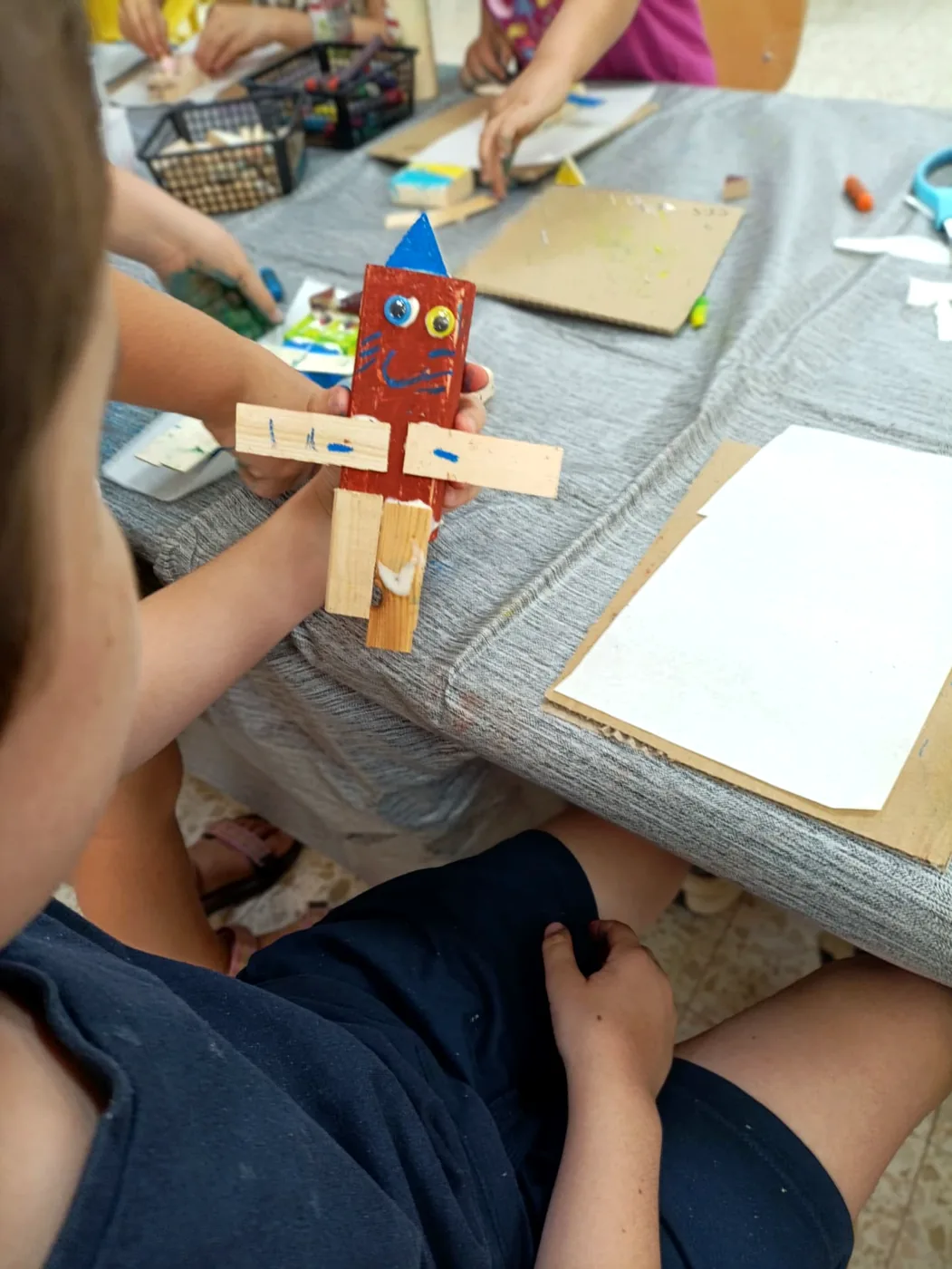 ילדה מחזיקה בגאווה את היצור שיצרה