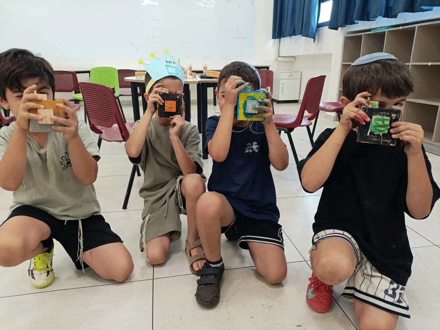ילדים מחזיקים מצלמות עץ שיצרו